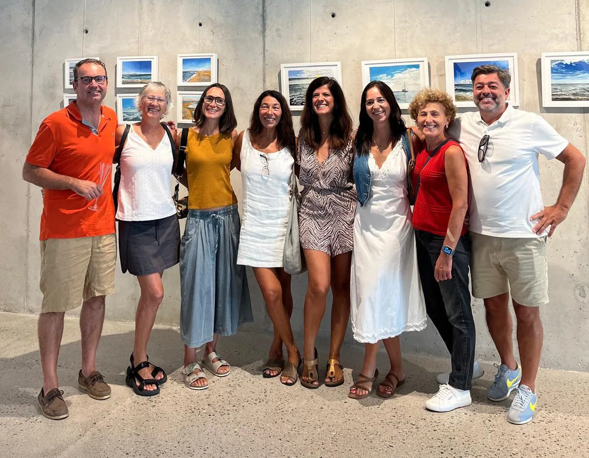 Grup de persones davant les obres exposades a la inauguració a Teià