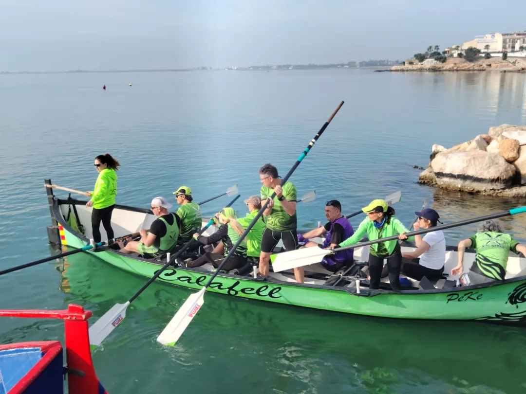 Tripulació compartida de Rem Premià i Calafell a bord d'una barca verda